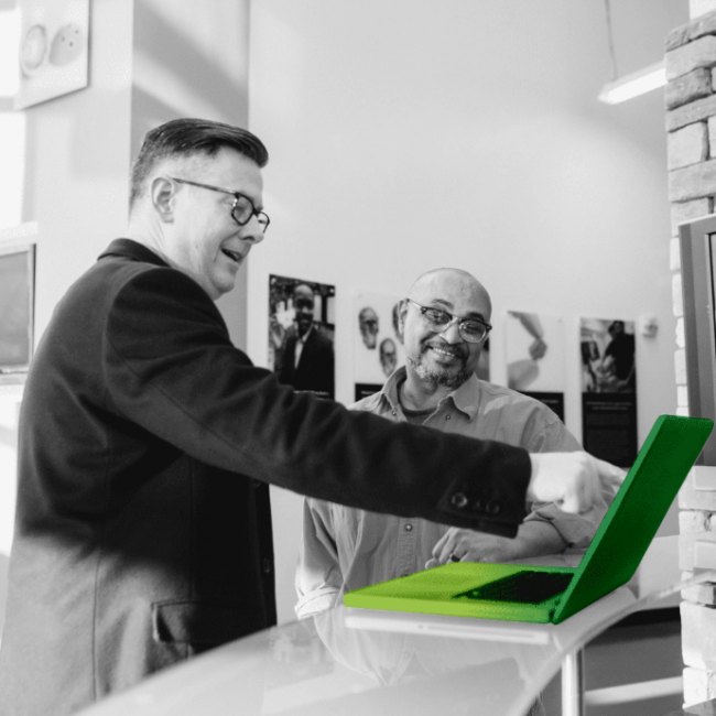 Man with glasses pointing on a laptop screen